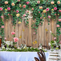 A Spring Floral Wood Plank Photoshoot Flowers Backdrop - ideasbackdrop, adorned with a "Better Together" sign, placed behind a long table set for a formal event by talented event decorators.