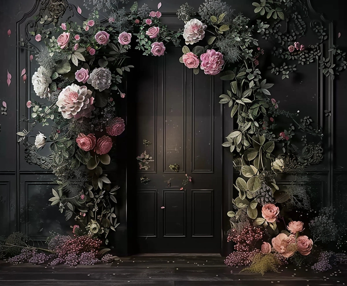 A black door is framed by an ornate floral arrangement, featuring large pink and white roses, green leaves, and small pink flowers against a dark Black Background Wall Bridal Shower Backdrop -ideasbackdrop by ideasbackdrop.