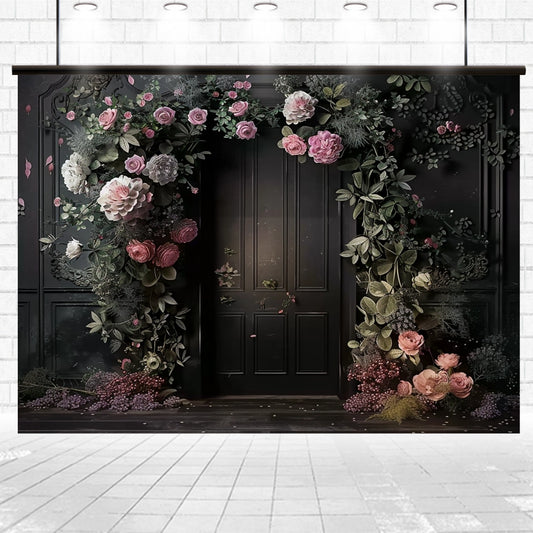 A dark doorway is adorned with a variety of pink and white flowers, with green leaves cascading down the sides and top, creating an enchanting floral arch. The surrounding area is dimly lit, making it a Black Background Wall Bridal Shower Backdrop - ideasbackdrop perfect for photo shoots.