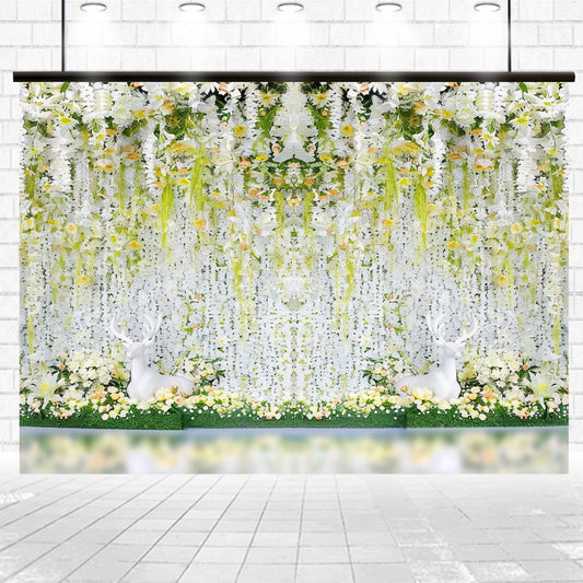 A decorative Bridal Shower Flower Party Wedding Backdrop-ideasbackdrop featuring white and yellow flowers, greenery, and two white deer sculptures against a white brick wall. Perfect for creating an unforgettable celebration by ideasbackdrop.