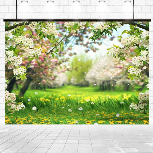 A backdrop of a vibrant, sunlit spring garden with green grass, yellow flowers, blooming trees, and white blossoms framed by branches. Captured in vivid detail and set against a white brick wall, this Cherry Flowers Meadow Grassland Floral Backdrop-ideasbackdrop by ideasbackdrop is perfect for photography sessions.