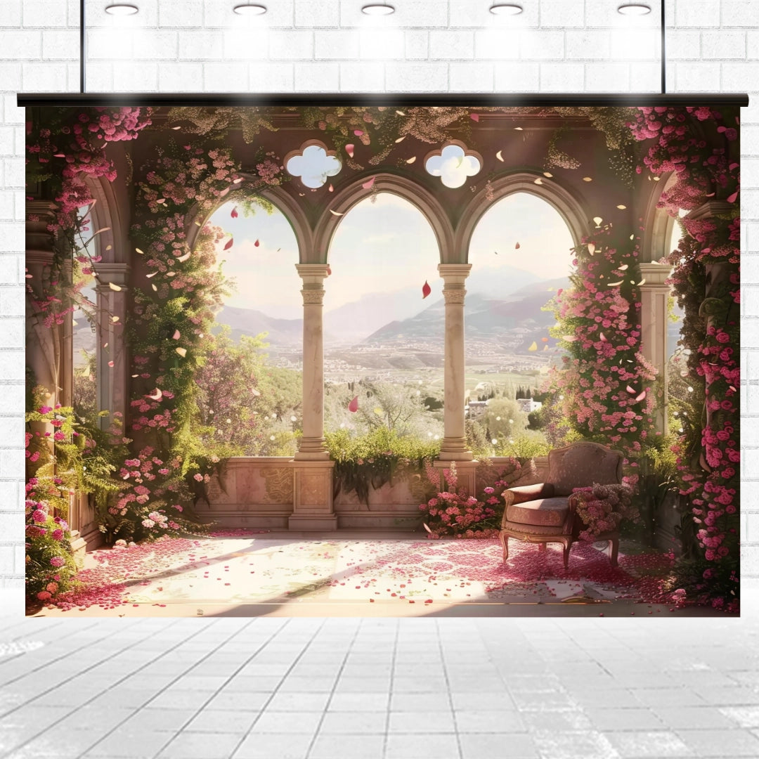 A bright, sunlit terrace adorned with climbing roses and overlooking a mountainous landscape, featuring three arched openings and a single cushioned chair, creates an HD vivid floral backdrop perfect for weddings. The scene is complemented by the European Style Window Flower Backdrop -ideasbackdrop from ideasbackdrop.