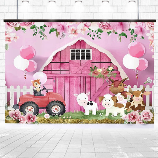A pink countryside barn backdrop with floral decorations, animals (cow, sheep, goat, fox driving a red tractor), white picket fence, balloons, and hay on the ground exudes rustic charm in a bright indoor space. This Farm Animal Baby Shower Birthday Barn Backdrop-ideasbackdrop by ideasbackdrop will bring a whimsical touch to any setting.