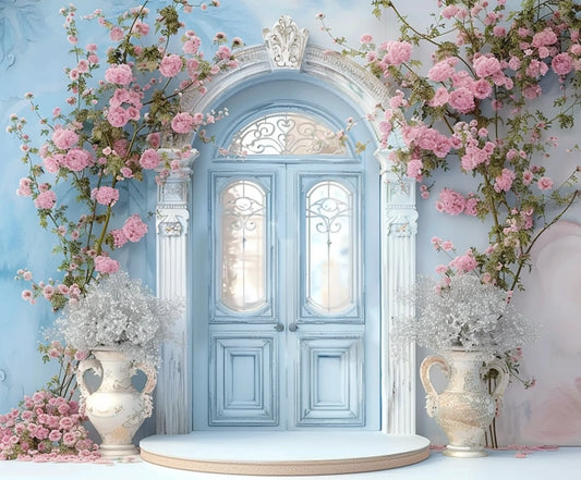 A Floral Blue Door Wall Bridal Shower Backdrop -ideasbackdrop by ideasbackdrop surrounded by pink flowers and vines, flanked by two large decorative vases with white floral arrangements, creating the perfect setting for a wedding backdrop that exudes floral elegance.