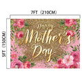 A "Glitter Flower Happy Mother's Day Backdrop-ideasbackdrop" with gold text, surrounded by pink flowers and green leaves. This HD quality backdrop from ideasbackdrop, with dimensions of 7 feet by 5 feet, is perfect to make memories on this special day.