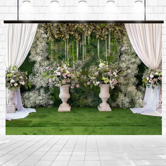 A Green Grassfield Wedding Flowers Backdrop by ideasbackdrop featuring lush greenery and floral arrangements in marble vases with draped white curtains on either side, set against a white tiled floor and wall, creating an immersive floral atmosphere.