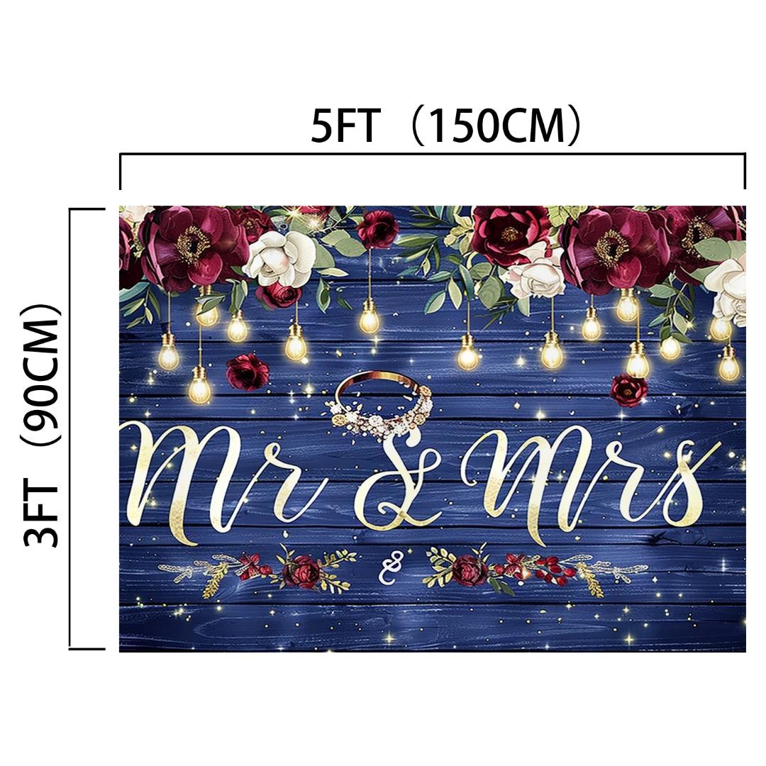 A 5ft by 3ft premium quality blue wooden backdrop with "Mr & Mrs" text, floral decorations, string lights, and a gold ring in the center. Perfect as a wedding decoration to create memorable photos. Introducing the Mr and Mrs Flower Rustic Wedding Backdrop-ideasbackdrop by ideasbackdrop.