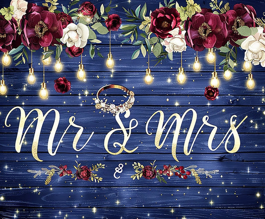 A decorative wedding sign on a premium quality backdrop, adorned with hanging lights, flowers, and the text "Mr & Mrs" in elegant script, with a ring placed in the center—introducing the Mr and Mrs Flower Rustic Wedding Backdrop-ideasbackdrop by ideasbackdrop.