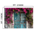 A rustic, weathered blue door surrounded by vibrant pink flowers and lush green foliage creates a realistic design. Measuring 5 feet (150 cm) tall and 7 feet (210 cm) wide, the Spring Flowers Old Wood Door Backdrop-ideasbackdrop by ideasbackdrop is perfect for home decor.