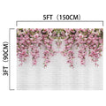 A high-resolution, white brick wall backdrop adorned with hanging pink flowers. Perfect for engagement photos, the Pink Bridal Brick Romantic Floral Backdrop by ideasbackdrop measures 5 feet (150 cm) wide and 3 feet (90 cm) high.