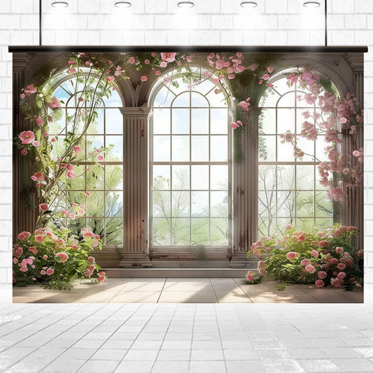 A large, decorative window with three arched sections is surrounded by blooming pink flowers and green vines, casting natural light into a tiled floor room with a white brick wall in the background—a perfect event aesthetic for weddings, featuring the Romantic Bridal Shower Window Flower Backdrop from ideasbackdrop.