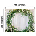 A Romantic Flower Wreath Bridal Wedding Backdrop-ideasbackdrop by ideasbackdrop, adorned with green leaves and white flowers, stands elegantly in front of a white draped wedding backdrop, creating picture-perfect moments.