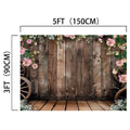 A Rustic Wood Barn Wall Leaves Flower Backdrop -ideasbackdrop with a high definition floral border at the top, wagon wheels on both sides, and dimensions labeled as 5 feet (150 cm) wide and 3 feet (90 cm) tall.