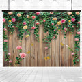 A wooden fence, adorned with climbing vines and pink roses, creates a beautiful floral backdrop. Several butterflies flutter around the Spring Floral Wood Plank Photoshoot Flowers Backdrop from ideasbackdrop. The fence stands on a tiled surface against a light brick wall background, perfect for event decorators searching for stunning settings.