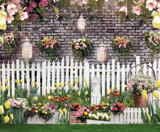 A garden with colorful tulips and roses, lanterns hanging on a white picket fence, and floral arrangements in baskets and pots against a brick wall background provides the perfect Spring Garden Fence Floral Brick Wall Flower Backdrop-ideasbackdrop by ideasbackdrop for photo shoots or events.