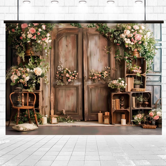 A rustic wooden backdrop with floral decorations, including pink and white flowers, green foliage, wooden crates, candles, and a chair is perfect for photography or themed parties. The "Spring Rose Flowers Wooden Arch Door Backdrop-ideasbackdrop" by ideasbackdrop is set against a white brick wall and tiled floor for an inviting touch.