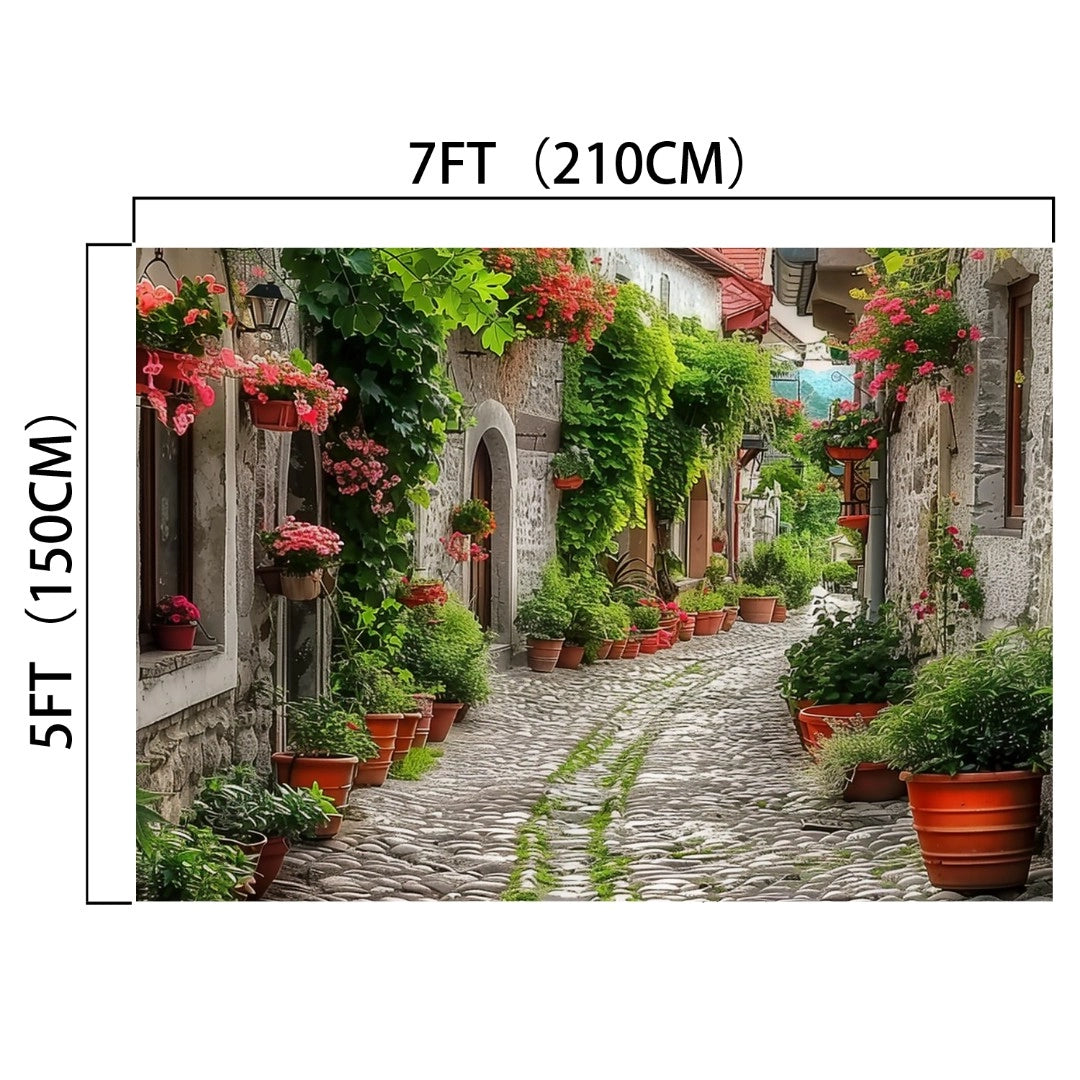 A cobblestone alleyway lined with potted plants and flowers, featuring stone buildings adorned with greenery, creates an HD Spring Alleyway Potted Flowers Backdrop. Dimensions: 7 feet (210 cm) wide and 5 feet (150 cm) tall. -ideasbackdrop