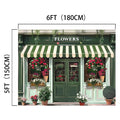 A green storefront with a striped awning labeled "FLOWERS," adorned with various potted plants and flowers, captures the essence beautifully. Bathed in natural light, this 6-foot (180 cm) wide and 5-foot (150 cm) tall scene looks like a Spring Flower Market Bloom Window Backdrop-ideasbackdrop from ideasbackdrop, bringing high-resolution imagery to life.