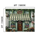A storefront with a green and white striped awning labeled "Flowers," decorated with various potted plants and flowers in vivid colors. Dimensions: 6FT (180CM) wide and 5FT (150CM) tall, this Spring Flowers Store Wood Door Backdrop-ideasbackdrop by ideasbackdrop brings a touch of realistic design to any setting.
