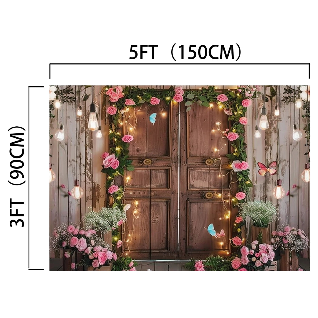 A Spring Photography Backdrop Wooden Barn Door -ideasbackdrop by ideasbackdrop adorned with ultra-realistic floral designs featuring pink roses, butterflies, and hanging lights, measuring 5 feet wide by 3 feet tall (150 cm by 90 cm), creating an elegant backdrop.