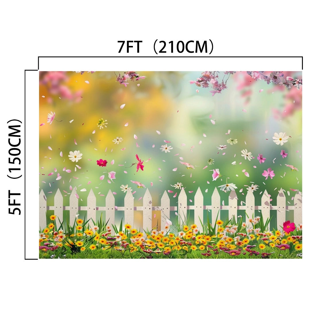 A 7ft (210cm) by 5ft (150cm) HD Spring Flowers Kids Birthday Pink Floral Backdrop -ideasbackdrop features a white picket fence with yellow and red flowers against a background of falling petals and a blurred green and pink landscape, perfect for online meetings.