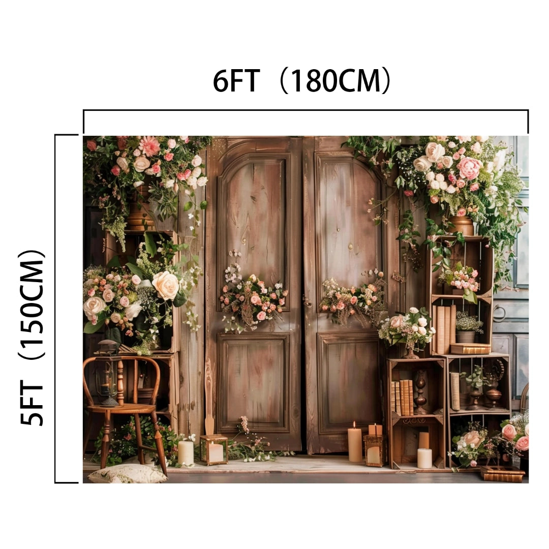 A Spring Rose Flowers Wooden Arch Door Backdrop-ideasbackdrop measuring 6 feet by 5 feet, decorated with pink and white flowers, green foliage, a wooden chair, and candles arranged in front for a photography setting or themed parties. This HD door backdrop from ideasbackdrop offers stunning details perfect for any occasion.