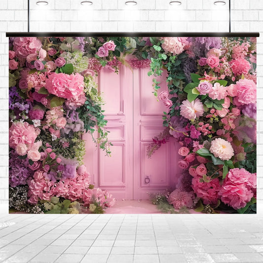 A Wedding Photography Scenery Flower Backdrop -ideasbackdrop from ideasbackdrop features a pink door surrounded by an abundance of realistic vibrant flowers in shades of pink, purple, and green set against a white brick wall backdrop.
