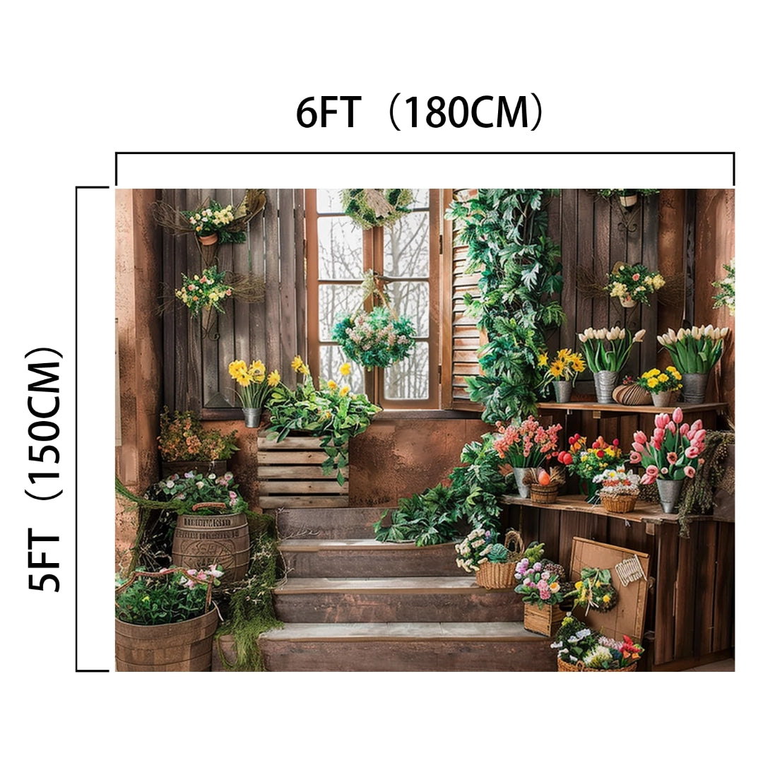 Indoor space with wooden stairs, decorated with a variety of potted flowers and greenery. A window with a floral wreath is centered on the back wall. Perfect for events and photography, this 6FT by 5FT area features a Wooden Window Garden Grass Floral Backdrop-ideasbackdrop crafted from high-quality material by ideasbackdrop.